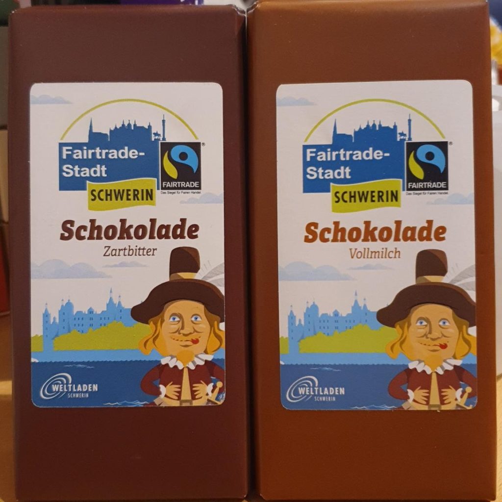 Fairtrade-Stadt Schwerin Schokolade Zartbitter und Vollmilch mit Petermännchenmotiv vorm Schloss